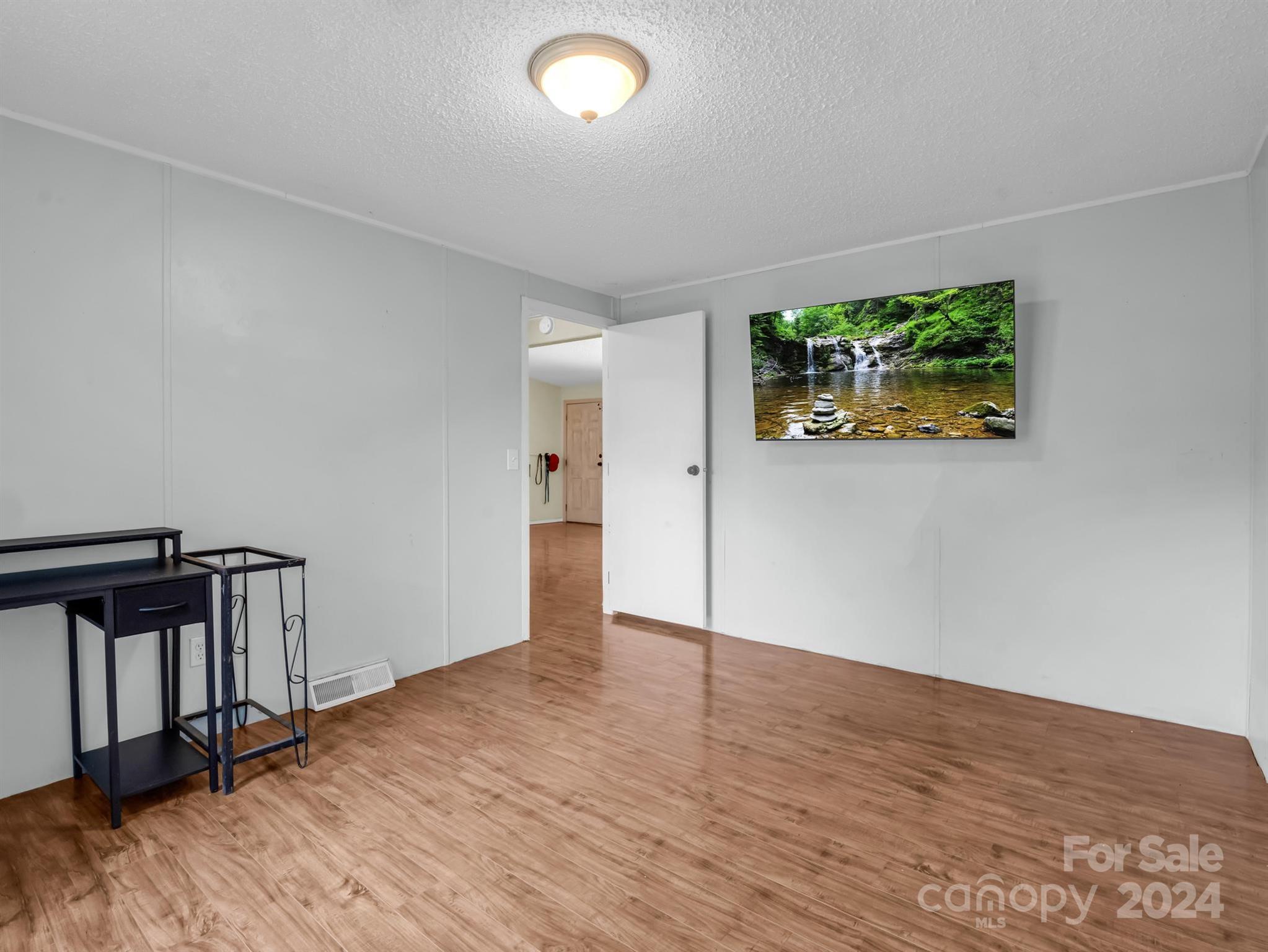 293 Bane Road Mills River, NC 28759 - Photo 28 of 48 an empty room with wooden floor and window