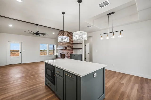 a kitchen with kitchen island granite countertop a sink a stove and cabinets
