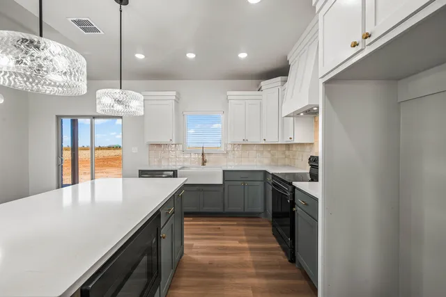 a kitchen with kitchen island granite countertop a sink a counter space appliances and cabinets