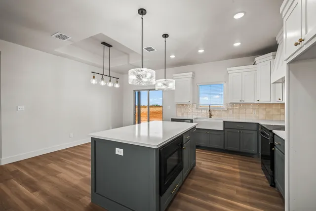 an empty room with wooden floor a ceiling fan and windows