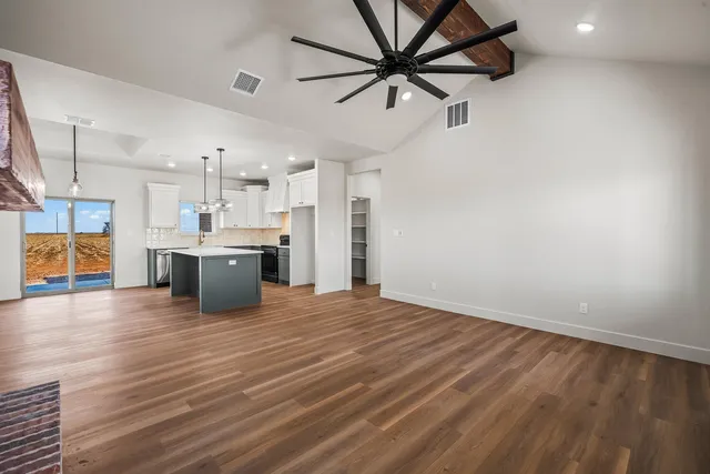 a large kitchen with granite countertop a large counter top a sink stainless steel appliances and cabinets