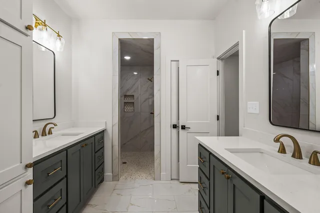 a bathroom with a double vanity sink mirror and shower