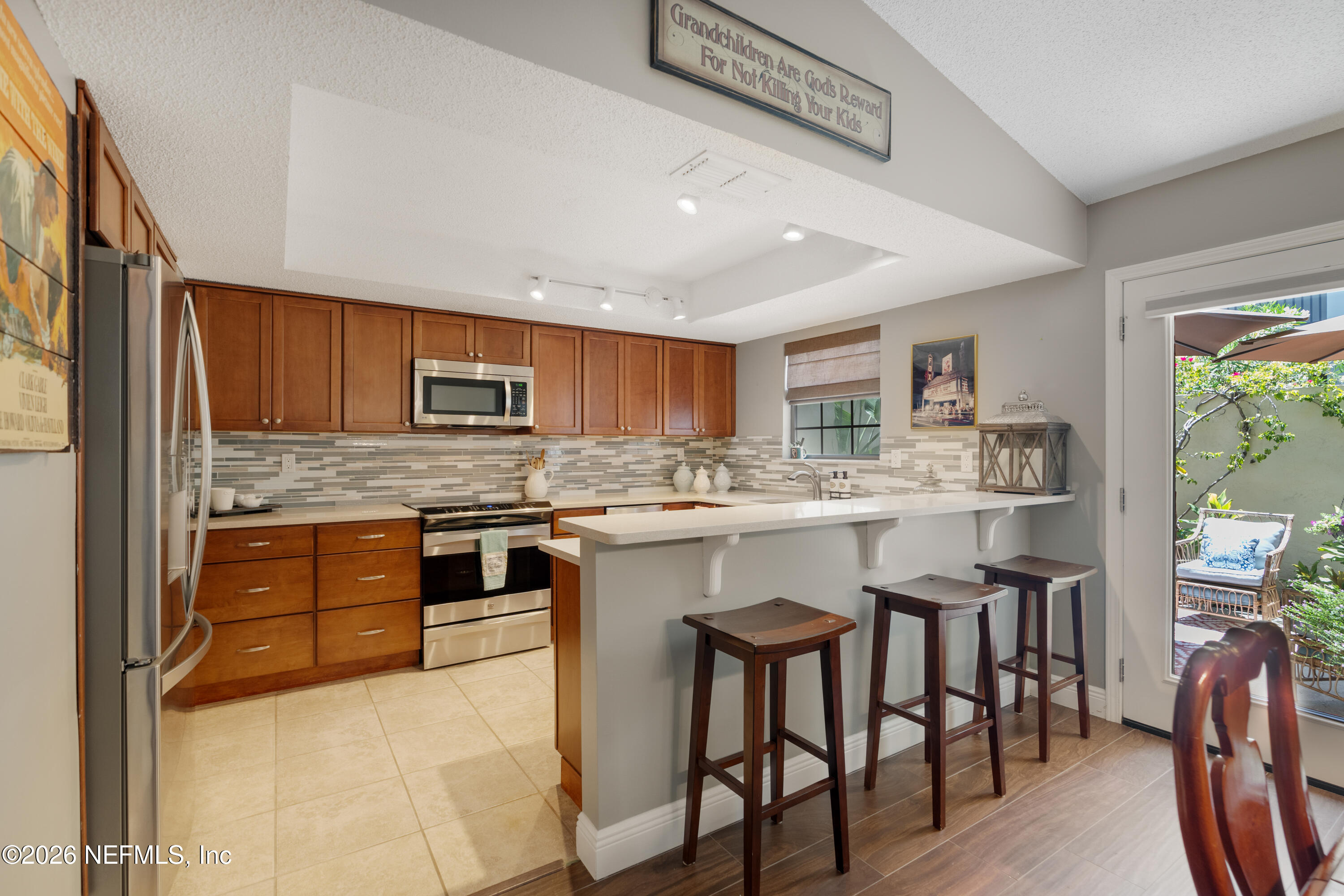 204 Gerado Street, Unit 3 St. Augustine, FL 32080 - Photo 11 of 31 a kitchen with stainless steel appliances granite countertop a stove top oven a sink dishwasher a dining table and chairs with wooden floor