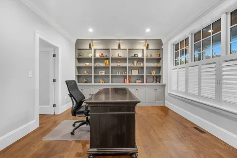 a view of a workspace with furniture and a bookshelf