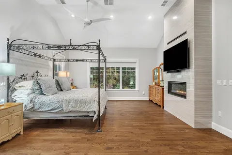 a spacious bedroom with a bed and a flat screen tv
