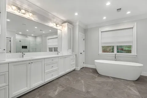 a spacious bathroom with a double vanity sink a mirror and a bathtub