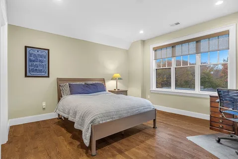 a bedroom with a bed and wooden floor