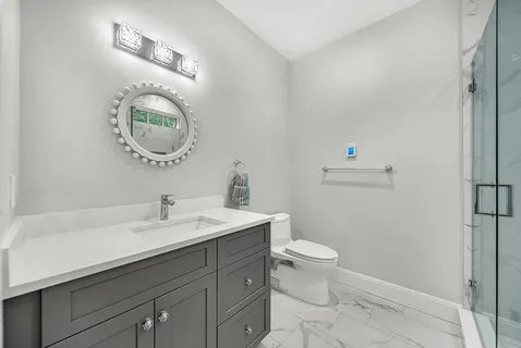 a bathroom with a toilet a sink and mirror