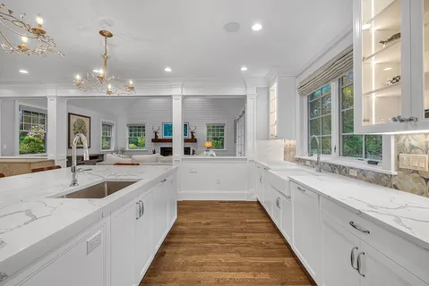 a large white kitchen with a large window