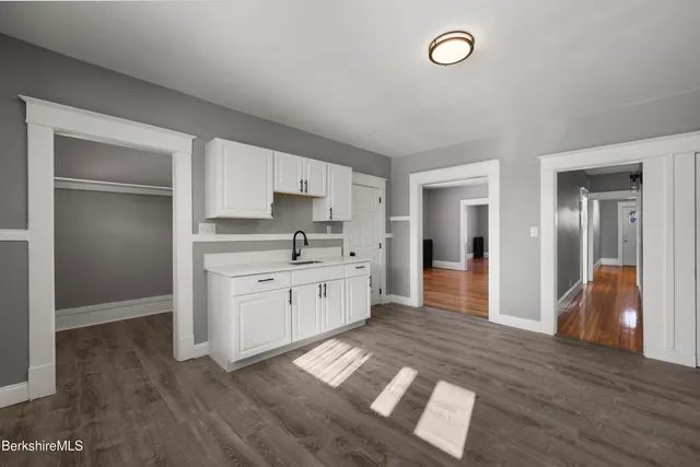 a kitchen with white cabinets and appliances