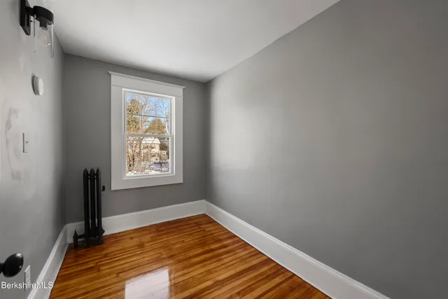 a view of a room with wooden floor and a window