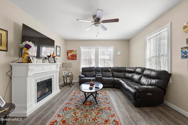 a living room with furniture a fireplace and a window