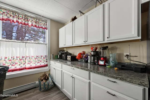 a kitchen with white cabinets and window