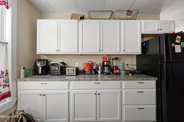 a kitchen with stainless steel appliances granite countertop a sink a refrigerator and cabinets