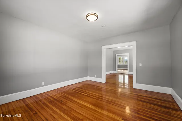a view of empty room with wooden floor
