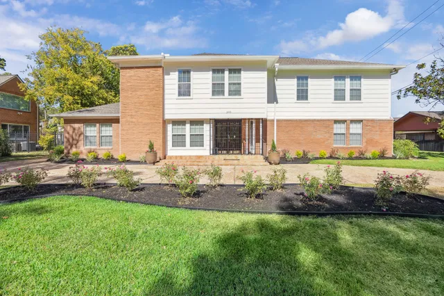 a front view of a house with a yard and potted plants