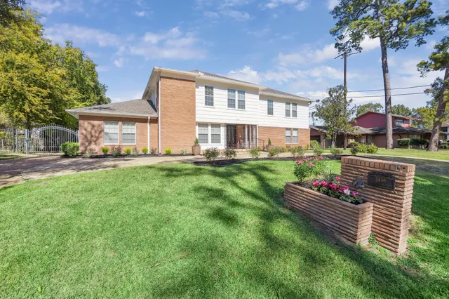 a view of a house with a big yard and a fountain