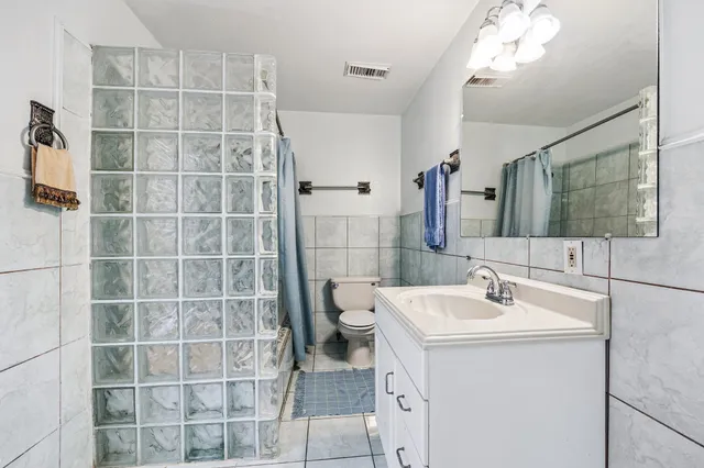 a bathroom with a sink a toilet and mirror