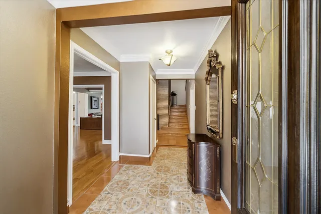 a view of a hallway with wooden floor and a bathroom