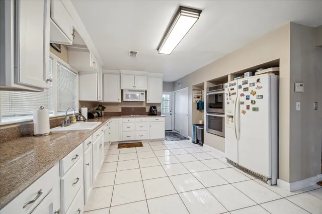 a kitchen with stainless steel appliances granite countertop a refrigerator and a stove