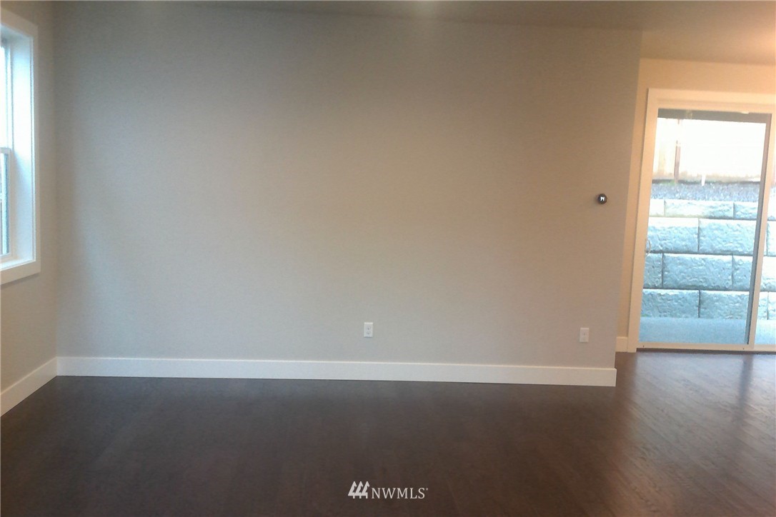 4323 223rd Place Southeast Bothell, WA 98021 - Photo 7 of 15 an empty room with wooden floor and windows with curtains