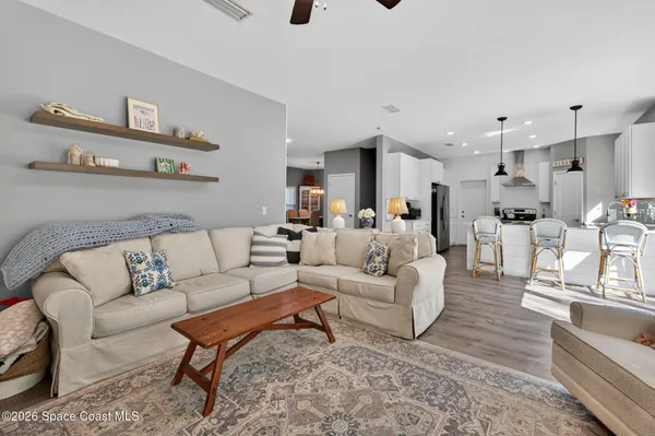 a living room with furniture and a view of kitchen