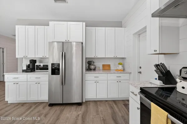 a kitchen with stainless steel appliances a stove a sink a refrigerator and cabinets