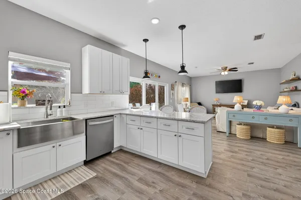 a kitchen with stainless steel appliances granite countertop a sink counter space and wooden floor