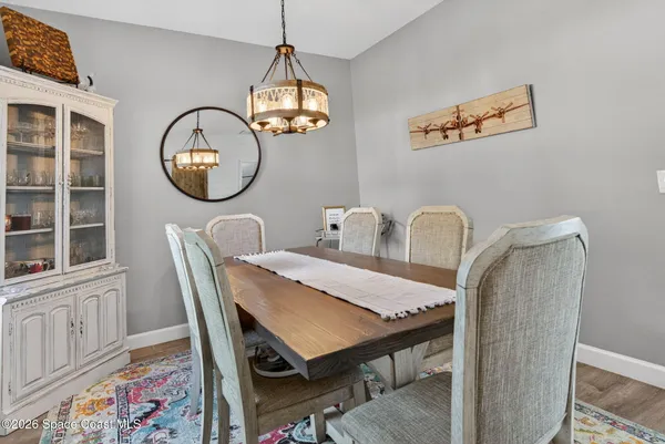 a view of a dining room with furniture and a chandelier