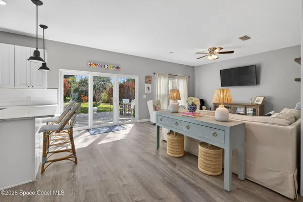 a living room with furniture a flat screen tv and kitchen view