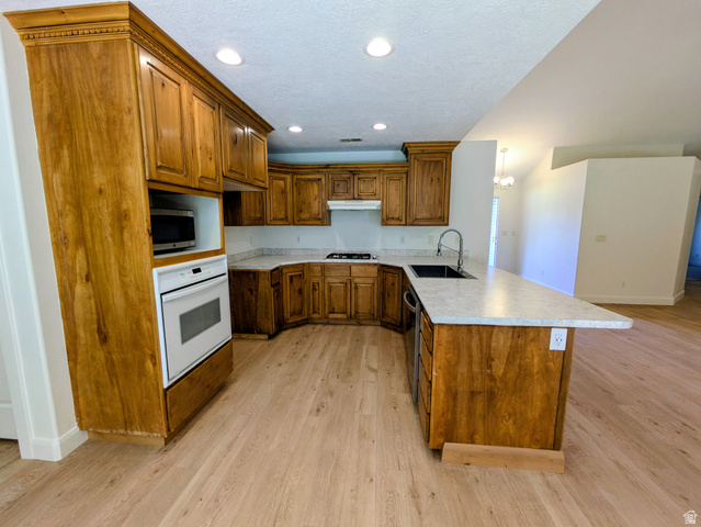 441 Main Street Hurricane, UT 84737 - Photo 23 of 29 Kitchen featuring wood-finish cabinetry, light-toned countertops, built-in oven, recessed lighting, and wood-finish flooring