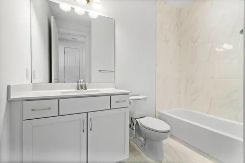 a bathroom with a sink toilet vanity and shower
