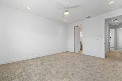 an empty room with windows and ceiling fan