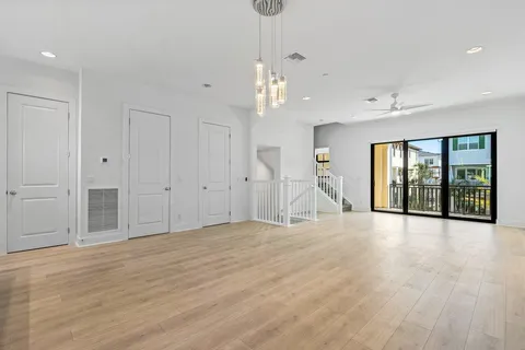 a view of an empty room with glass door and windows
