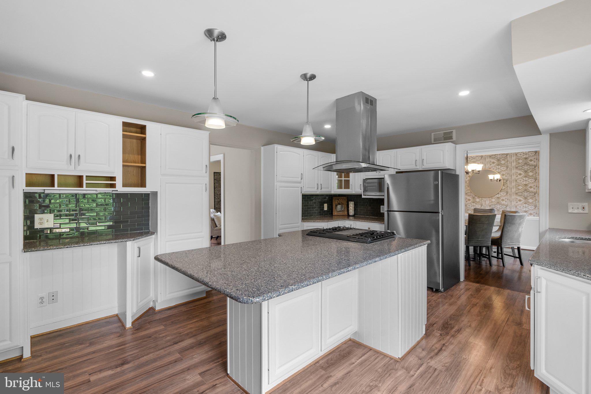 14201 Ansted Road Silver Spring, MD 20905 - Photo 15 of 44 a kitchen with stainless steel appliances granite countertop a kitchen island a stove and a wooden floors