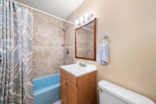a bathroom with a granite countertop sink a toilet and shower