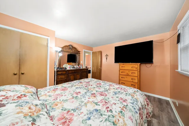 a bedroom with a bed and a flat screen tv