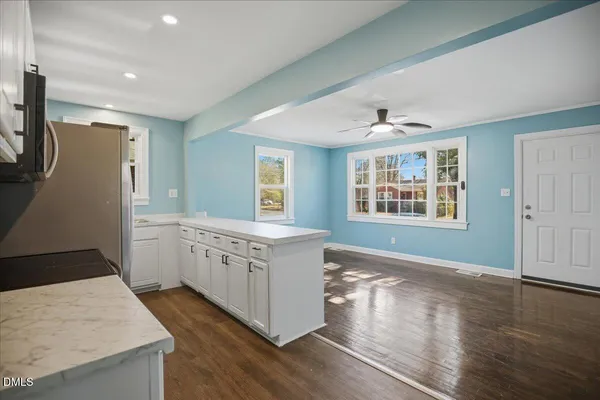 a kitchen with a sink a stove top oven and wooden floor