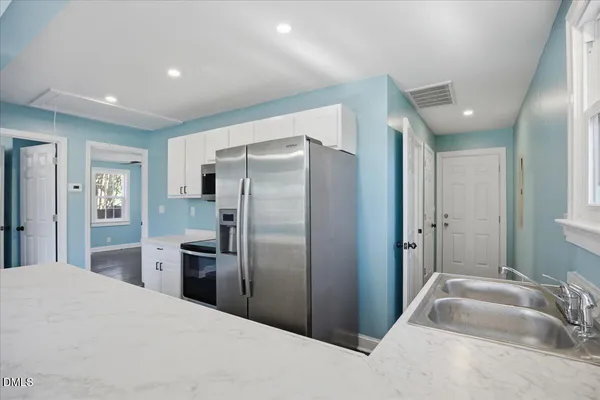 a kitchen with stainless steel appliances granite countertop a stove a sink and a refrigerator