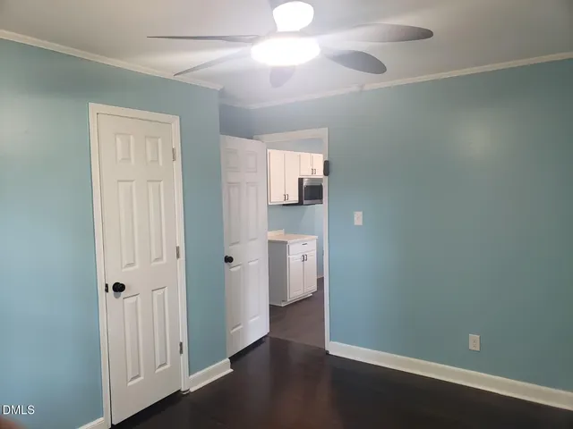 an empty room with a bathroom and a ceiling fan