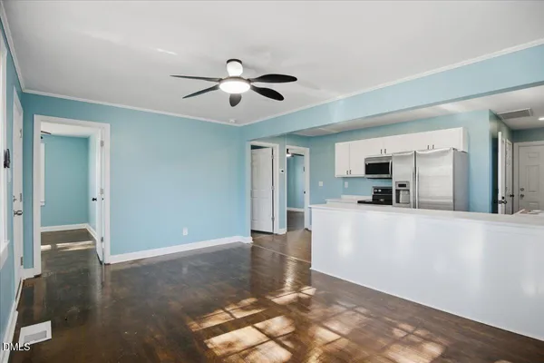 a living room with stainless steel appliances kitchen island granite countertop furniture a rug and a window