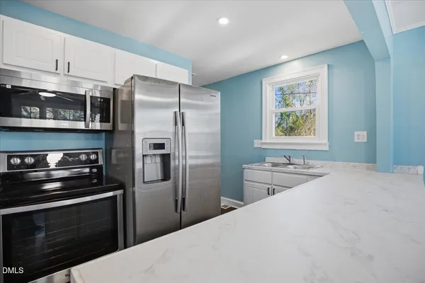 a kitchen with stainless steel appliances a stove refrigerator sink and microwave