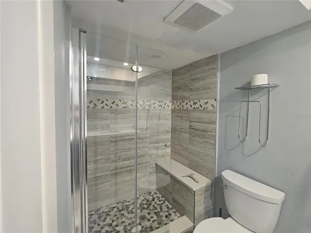 a bathroom with a shower a toilet and sink