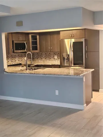 a view of kitchen with stainless steel appliances granite countertop sink and cabinets