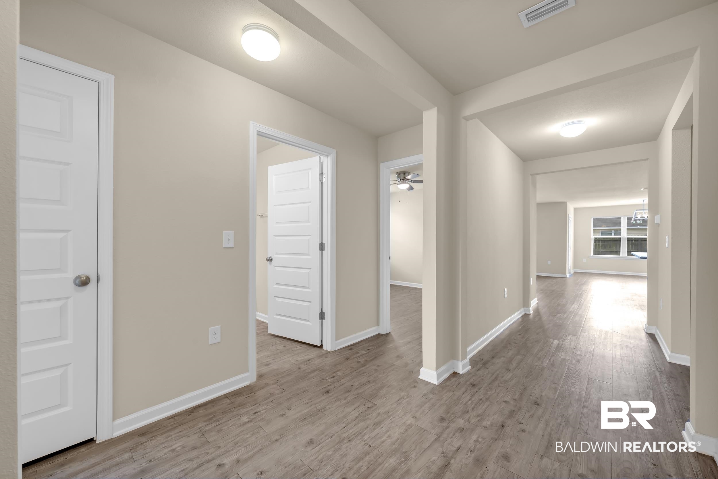 17344 Harding Drive Foley, AL 36535 - Photo 26 of 46 Hallway featuring wood-finish flooring, light-toned walls, white trim, and flush-mount lighting fixtures
