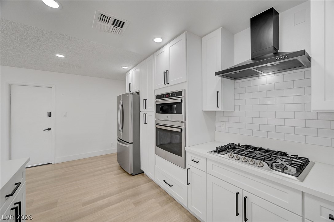 4840 Summerhill Road Las Vegas, NV 89121 - Photo 20 of 56 A pristine modern kitchen awaits, featuring sleek white cabinetry and stainless steel appliances.