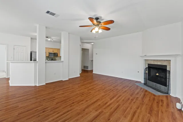 a view of empty room with wooden floor and fireplace