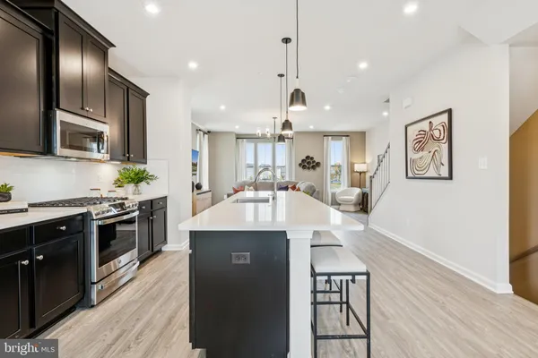 a large kitchen with stainless steel appliances granite countertop a stove and a wooden floors