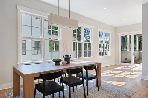 a dining room with a table chairs and kitchen view
