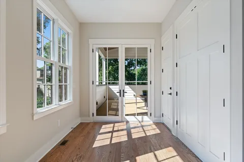 a bath room with a floor to ceiling window and wooden floor